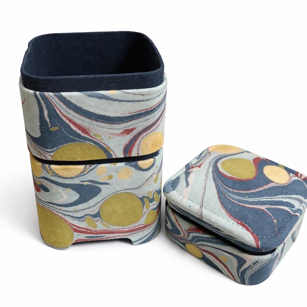 Two fabric containers with a marbled pattern on a white background