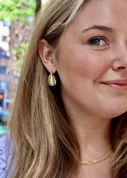 Woman with blonde hair with textured dome earrings on