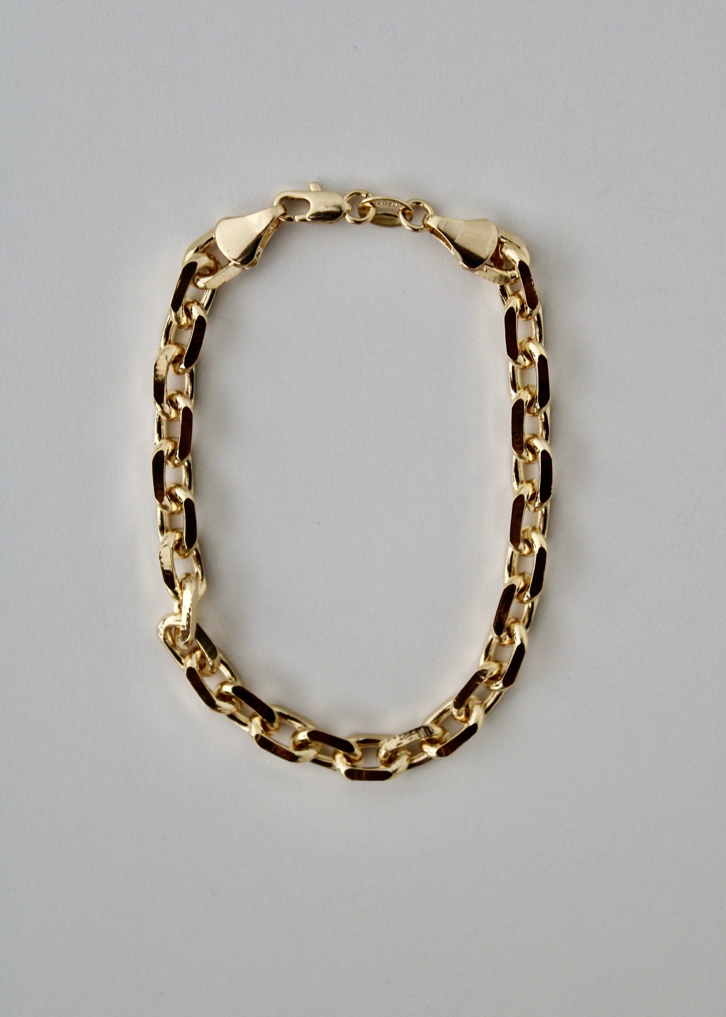 Gold knife-edge chain bracelet on a white background
