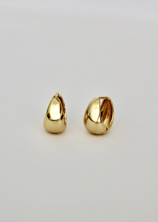 Pair of gold teardrop-shaped earrings on a light gray background