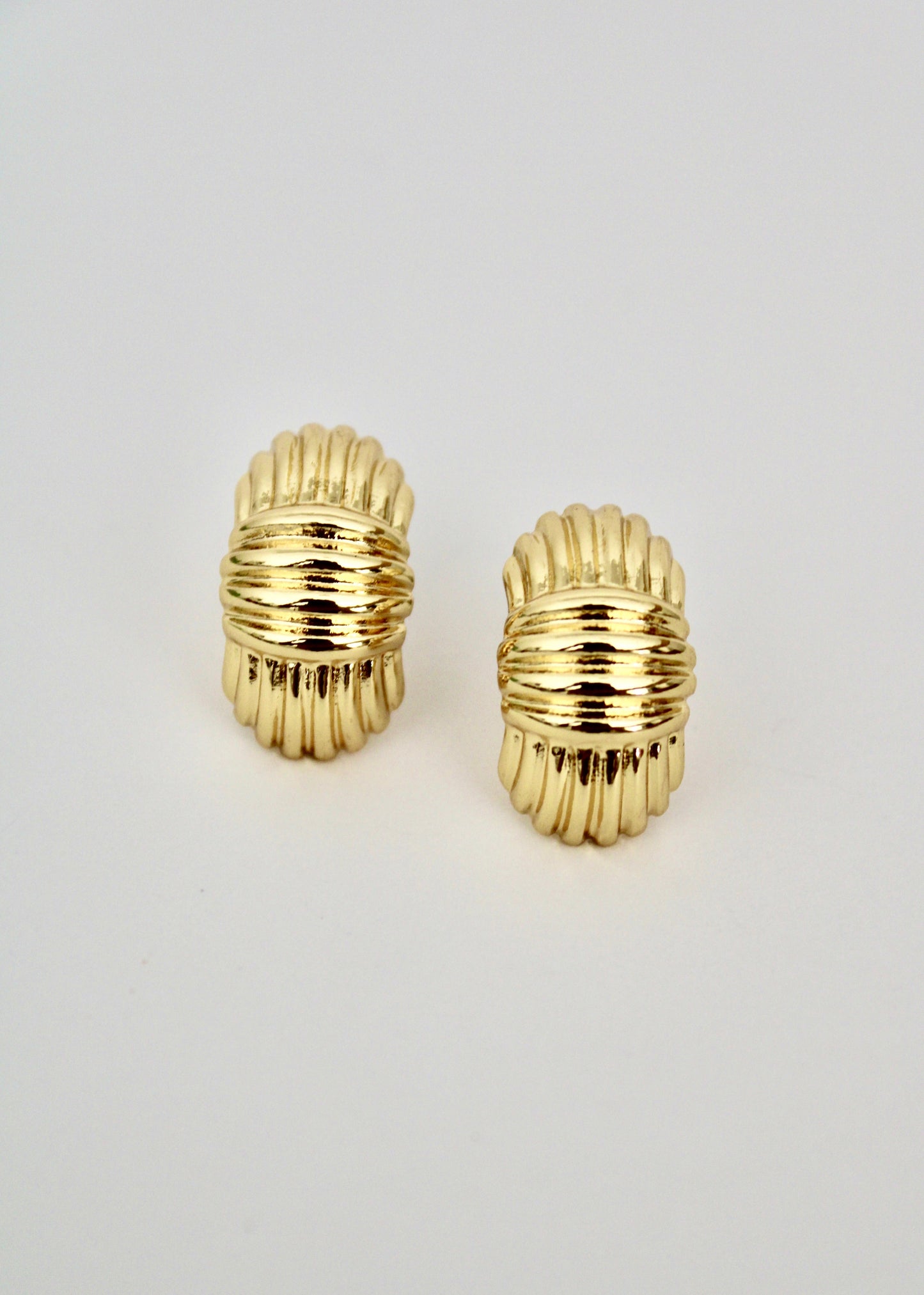 Pair of gold hoop earrings on a light gray background
