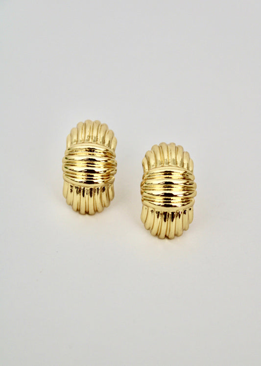 Pair of gold hoop earrings on a light gray background