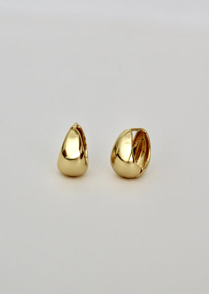 Pair of gold teardrop-shaped earrings on a light gray background