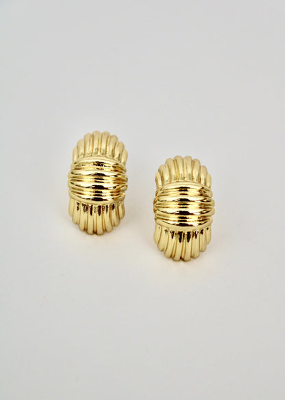 Pair of gold hoop earrings on a light gray background
